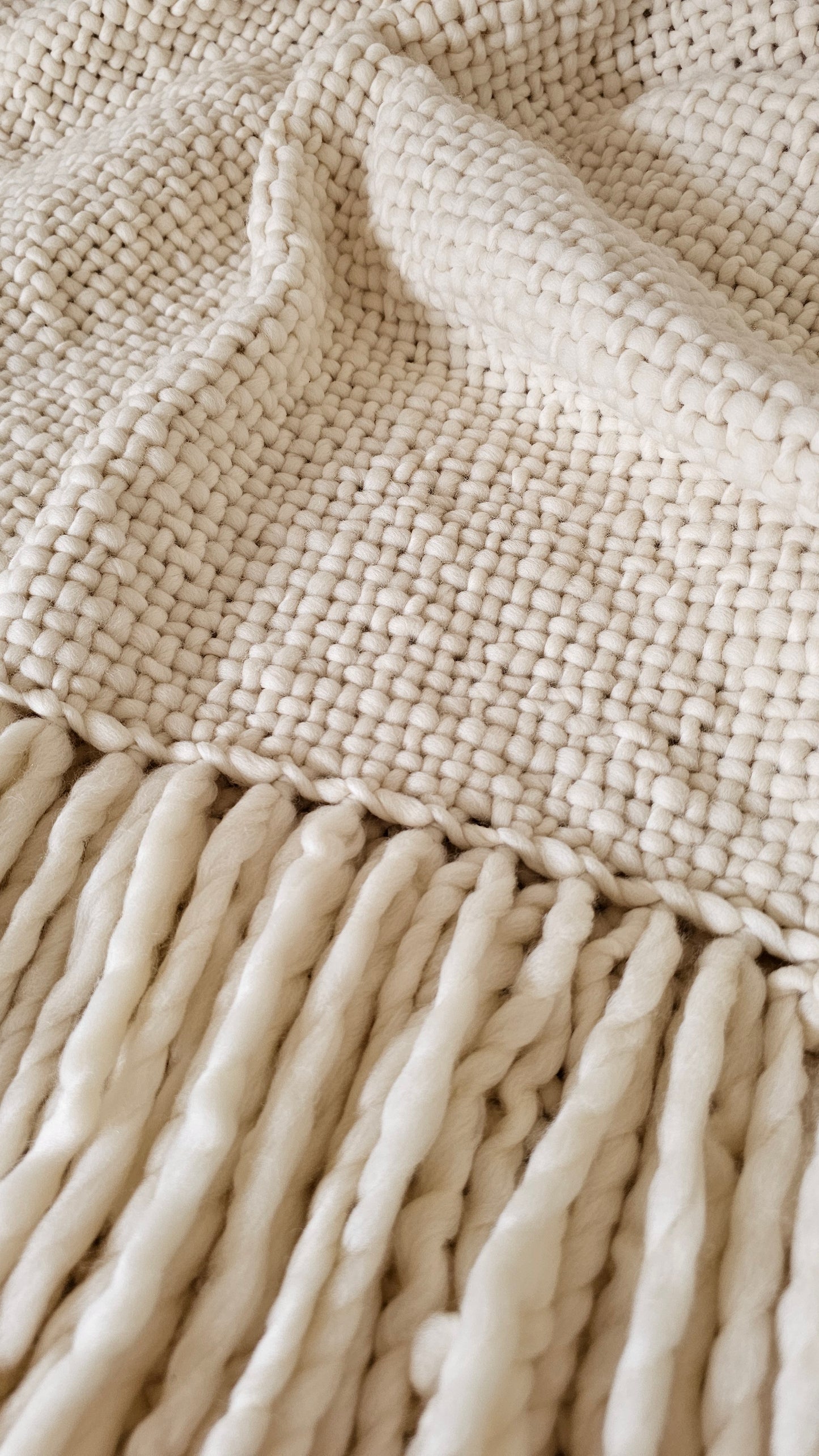 Detalle de manta de lana merino crudo natural tejida artesanalmente en telar