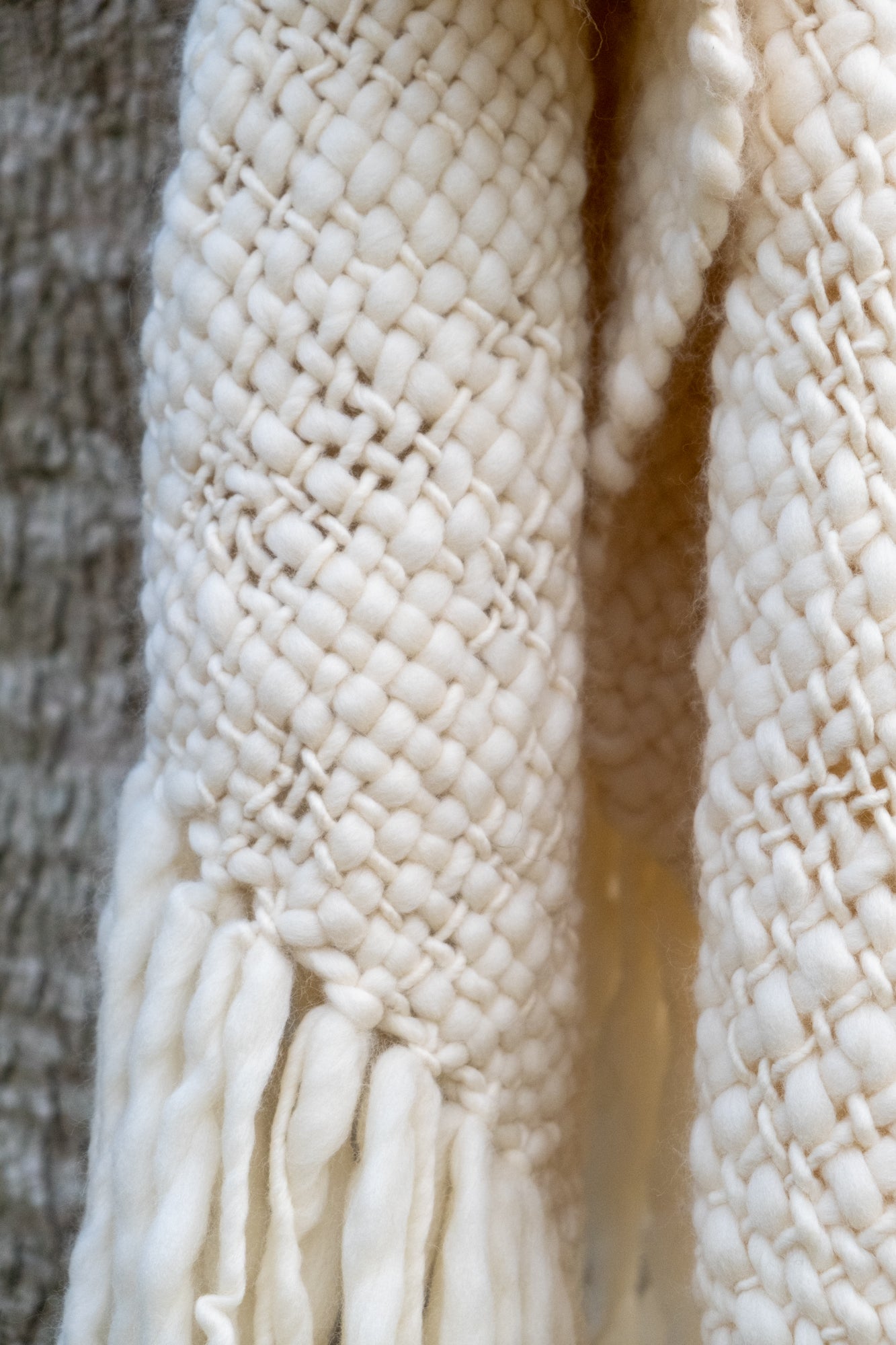 Detalle de la textura y flecos del chal de lana merino crudo natural